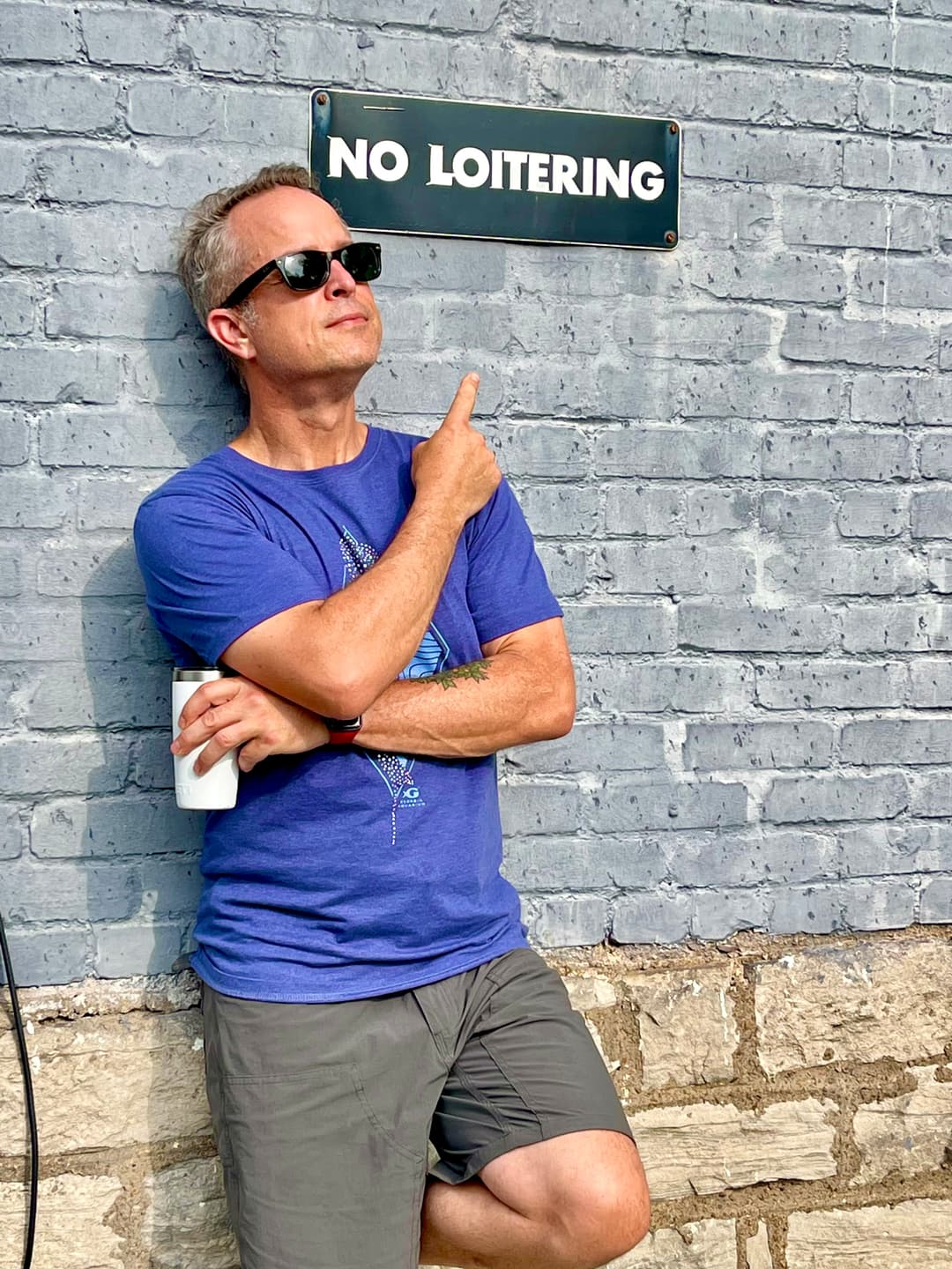 Brad Wood pointing at a No Loitering sign